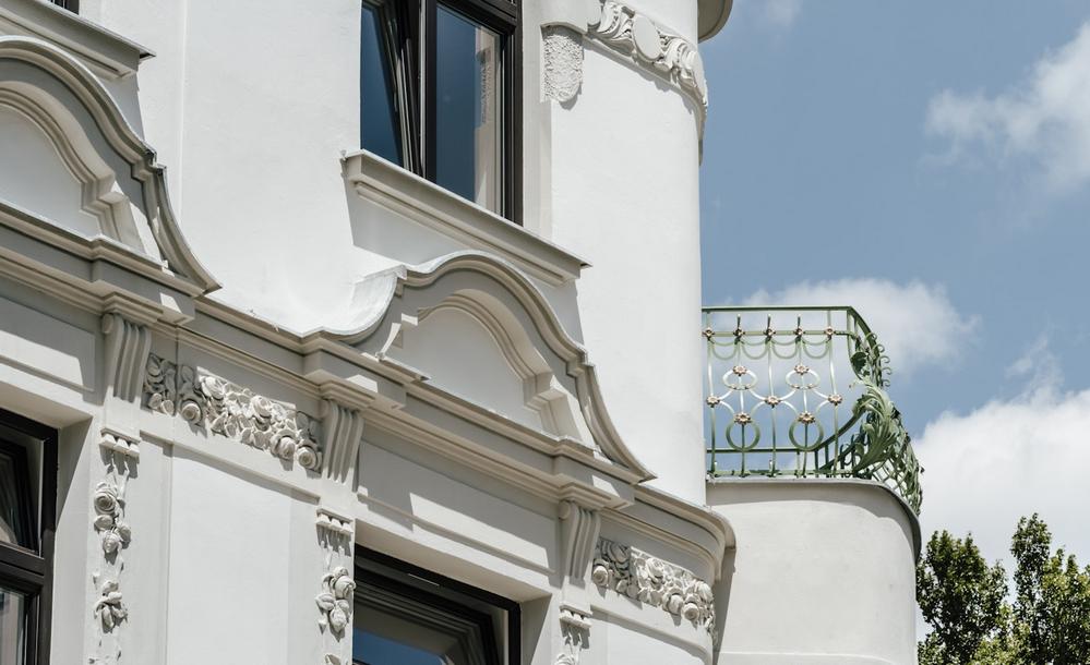 Bild Sanierung Eigentumswohnungen Hasnerstraße Wien: Detailsansicht der Stuckfassade eines Mehrfamilienhauses