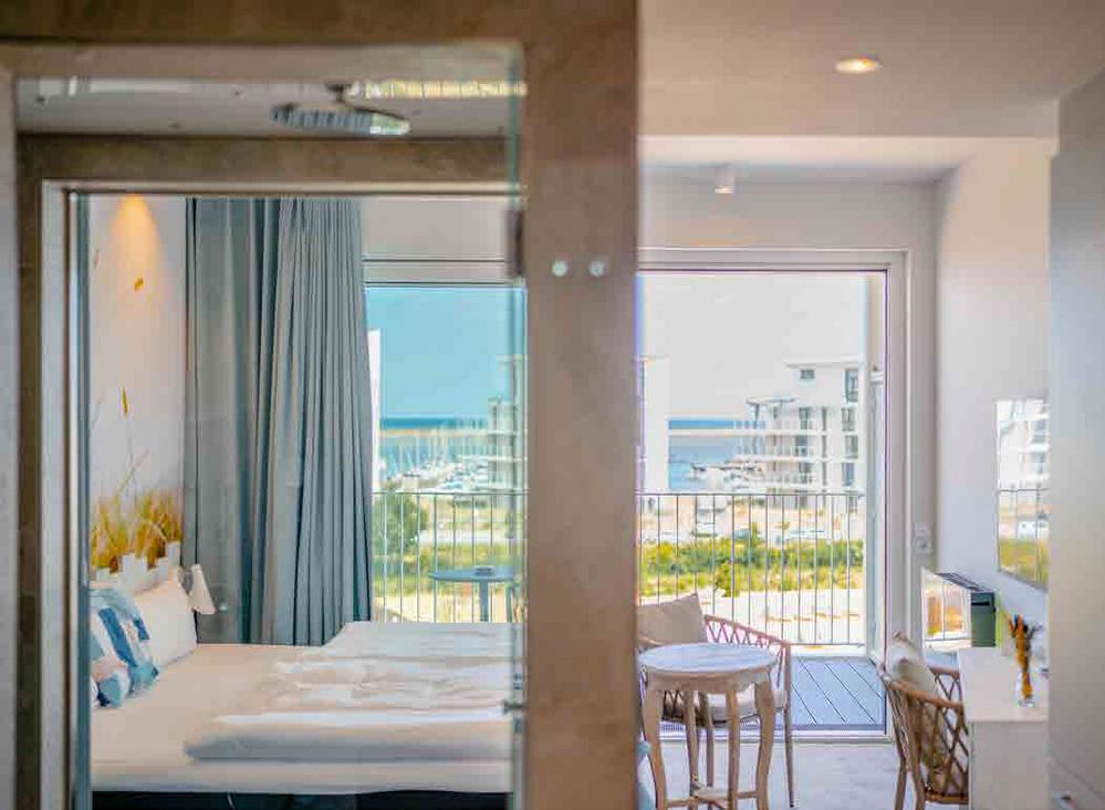 Bild Neubau Ferienapartments Marina Wendtorf Kiel: Fassade eines modernen Hotels mit Palme