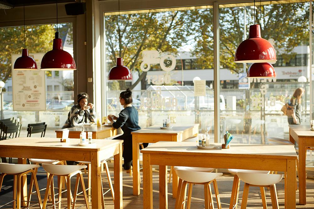 Bild Neubau Eigentumswohnungen und Häuser Bonner Straße Köln: Bild eines Restaurants mit Menschen