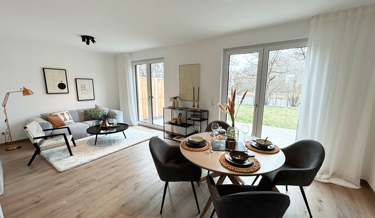 Wohnzimmer mit bodentiefen Fenstern mit Blick in den Garten
