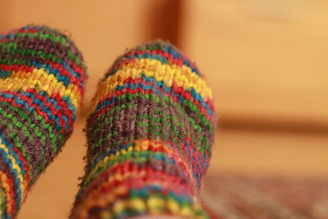 Mit bunten, warmen Socken die Füße hochlegen und wohlige Wärme genießen
