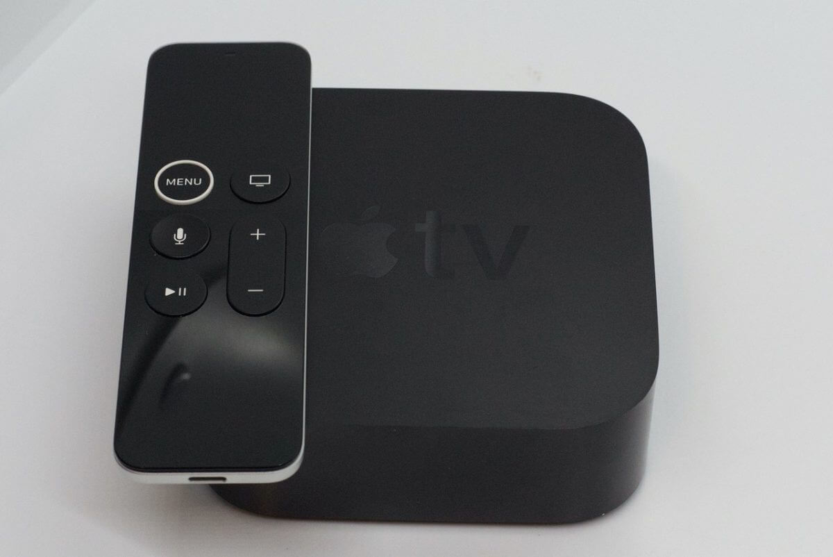 Draufsicht: schwarzer Apple TV inkl. Fernbedienung.