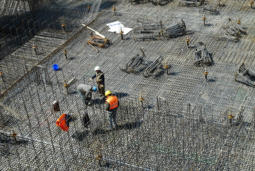 Baustelle mit drei Bauarbeitern. Würde das Schneller Bauen Gesetz in Kraft treten, könnte es in Berlin in Zukunft noch mehr Baustellen geben.