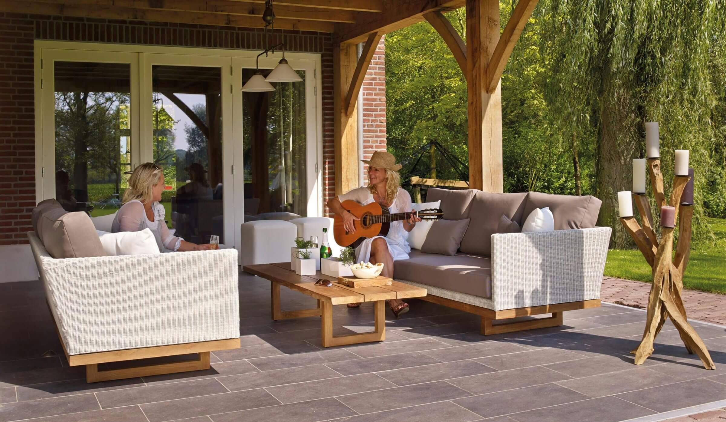 Zwei Frauen auf der Terrasse machen Musik mit der Gitarre.