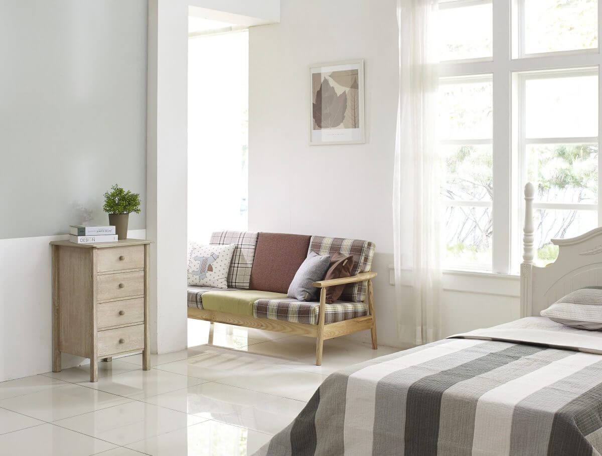 Helles Schlafzimmer mit großem Fenster und gemütlicher Einrichtung.