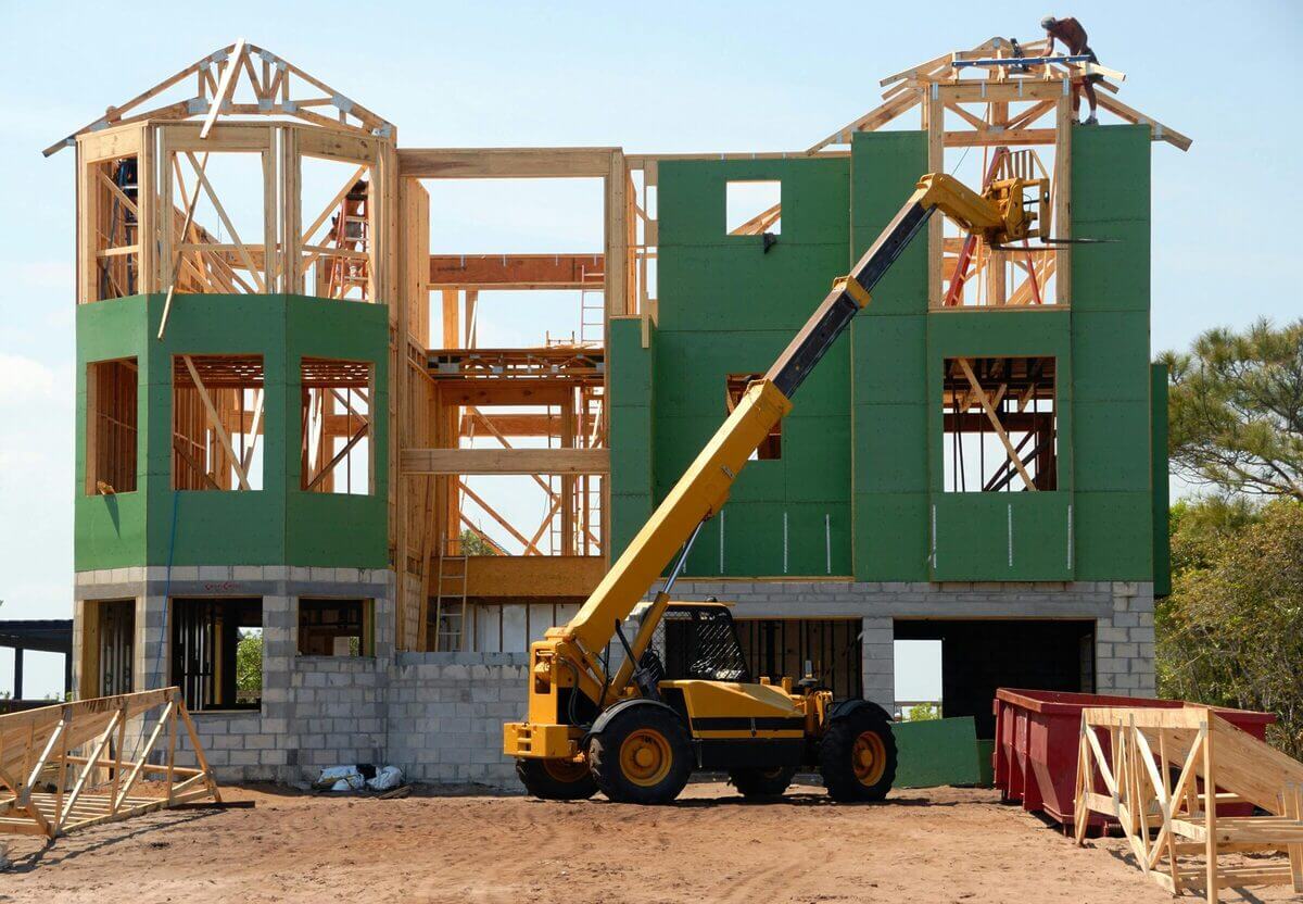 Aufstockung eines Wohngebäudes in Holzständerbauweise. Sichtbare Bauphase mit Kran und offenem Tragwerk.