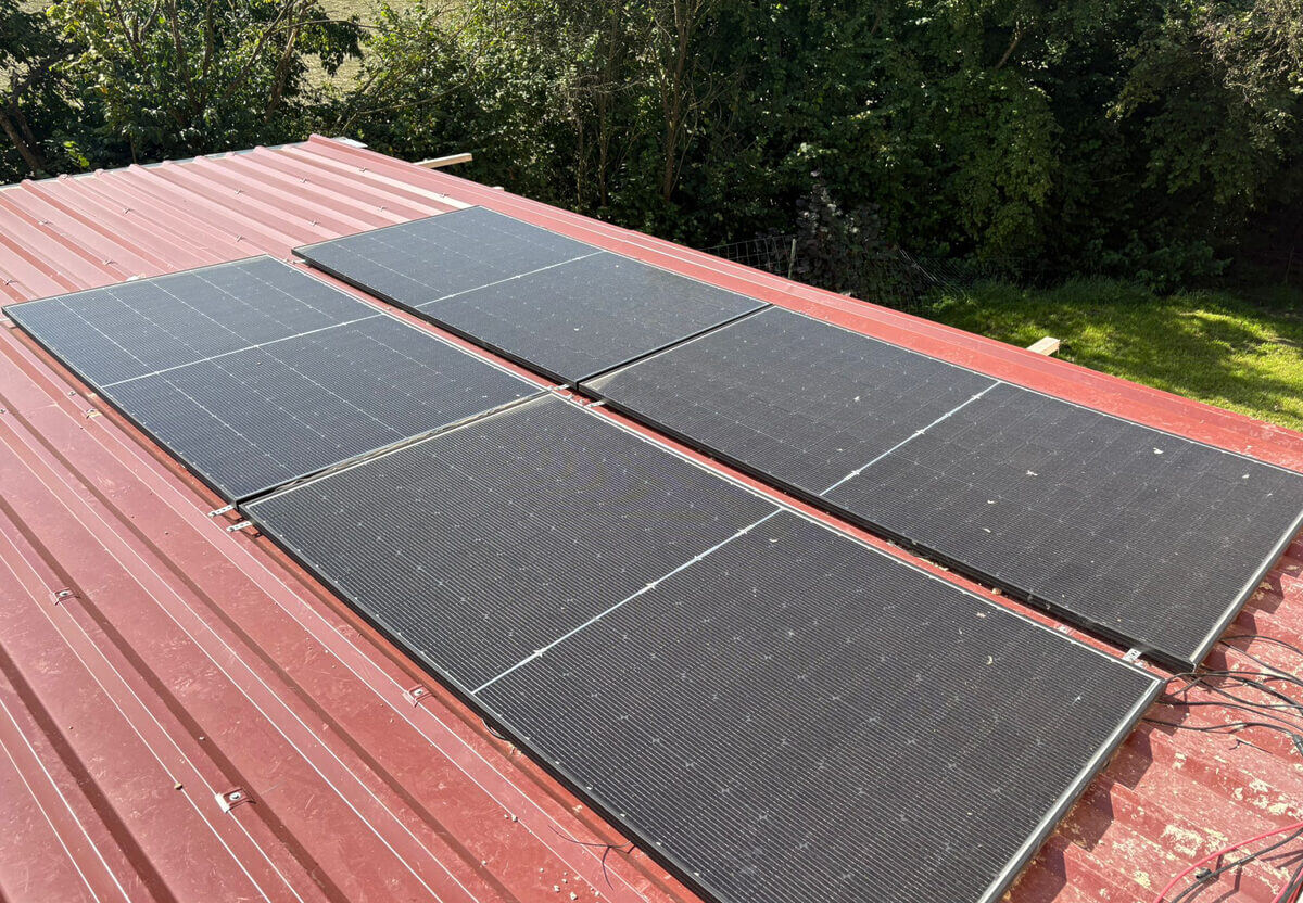 Solarmodule auf einem roten Blechdach.