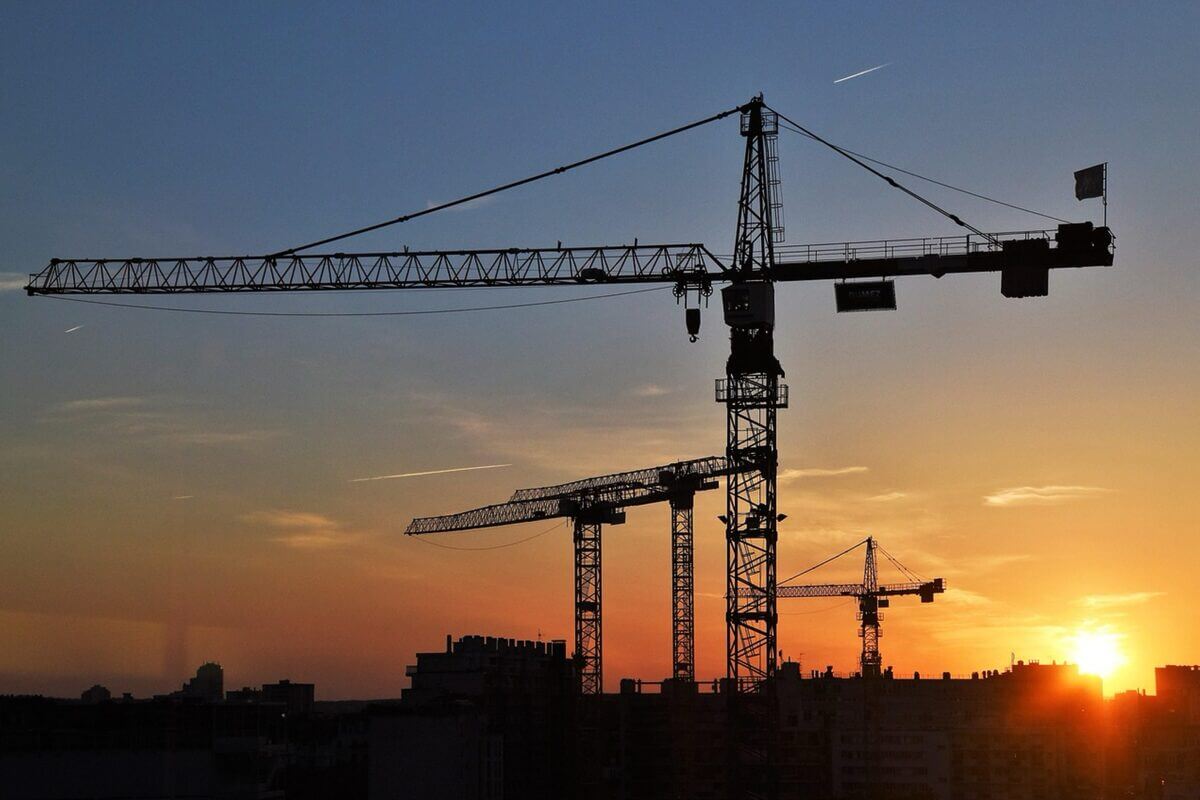 Abendrot über Baustelle mit Blick auf Kräne